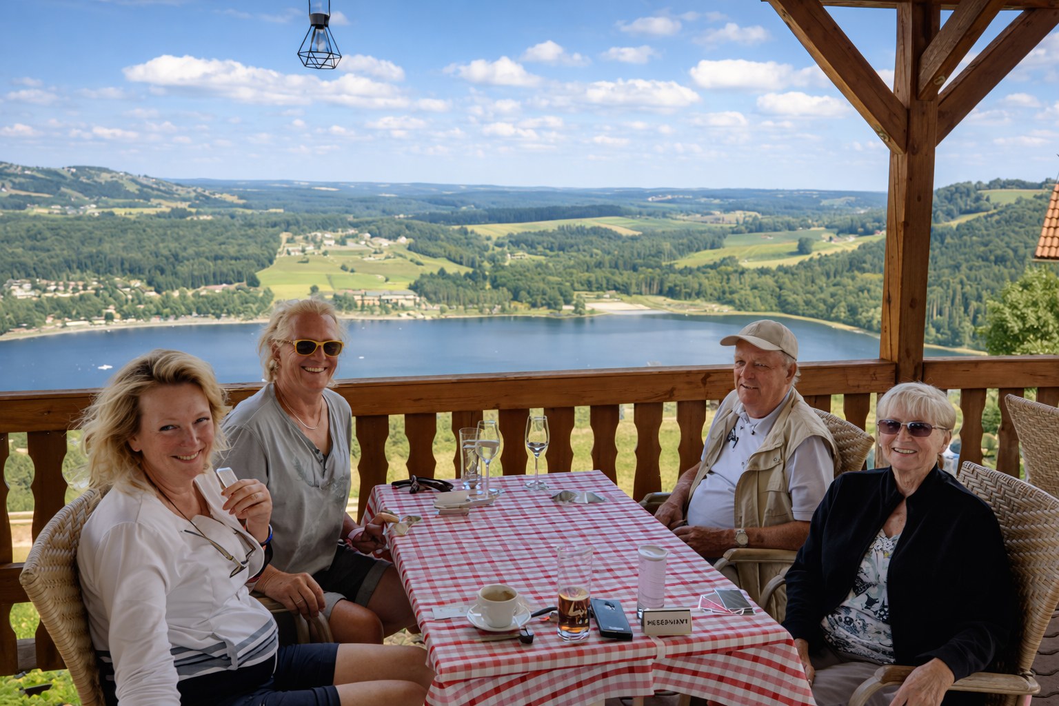 Die Familie der Bezirks Alm gemeinsam an einem Tisch mit Ausblick auf einen See
