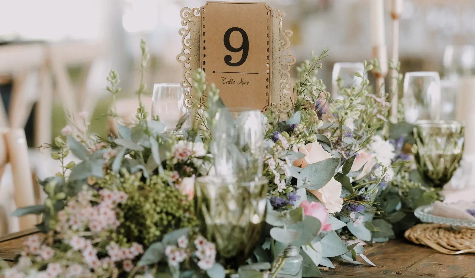 Festlich gedeckte Tafel mit langem Blumenstecker, Gläsern und Stoffservietten